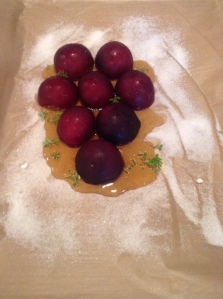 Place the plums cut-side down on top of sugar and honey. Sprinkle thyme leaves over the plums and into the honey.
